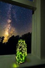 Fireflies In Jar On Window Sill With Night Sky